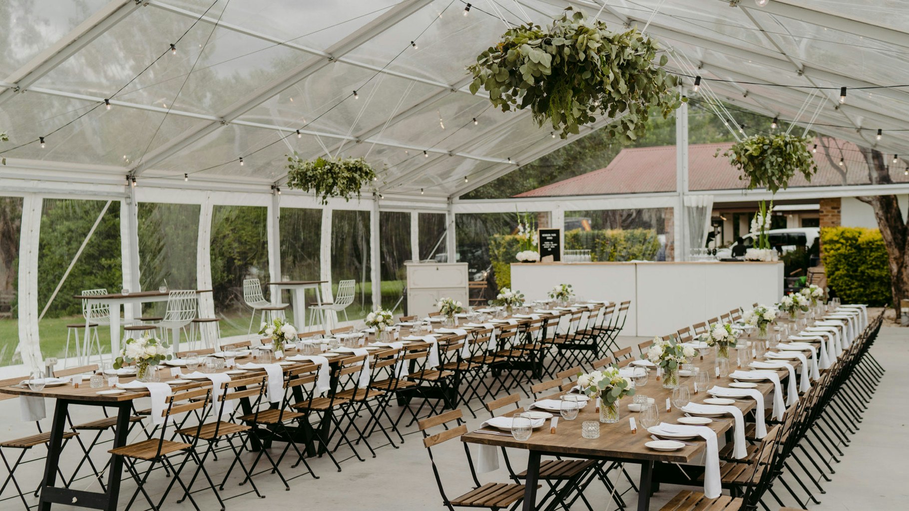 Wedding reception table styling within a clear marquee.